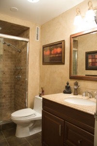 View of bathroom sink, toilet, and tile shower