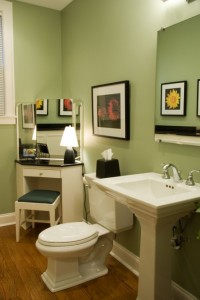 View of green bathroom with white toilet and sink